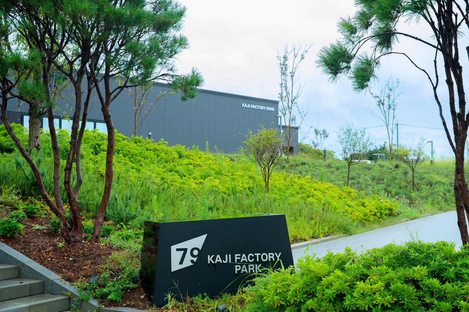 緑に囲まれたKAJI FACTORY PARKの入口